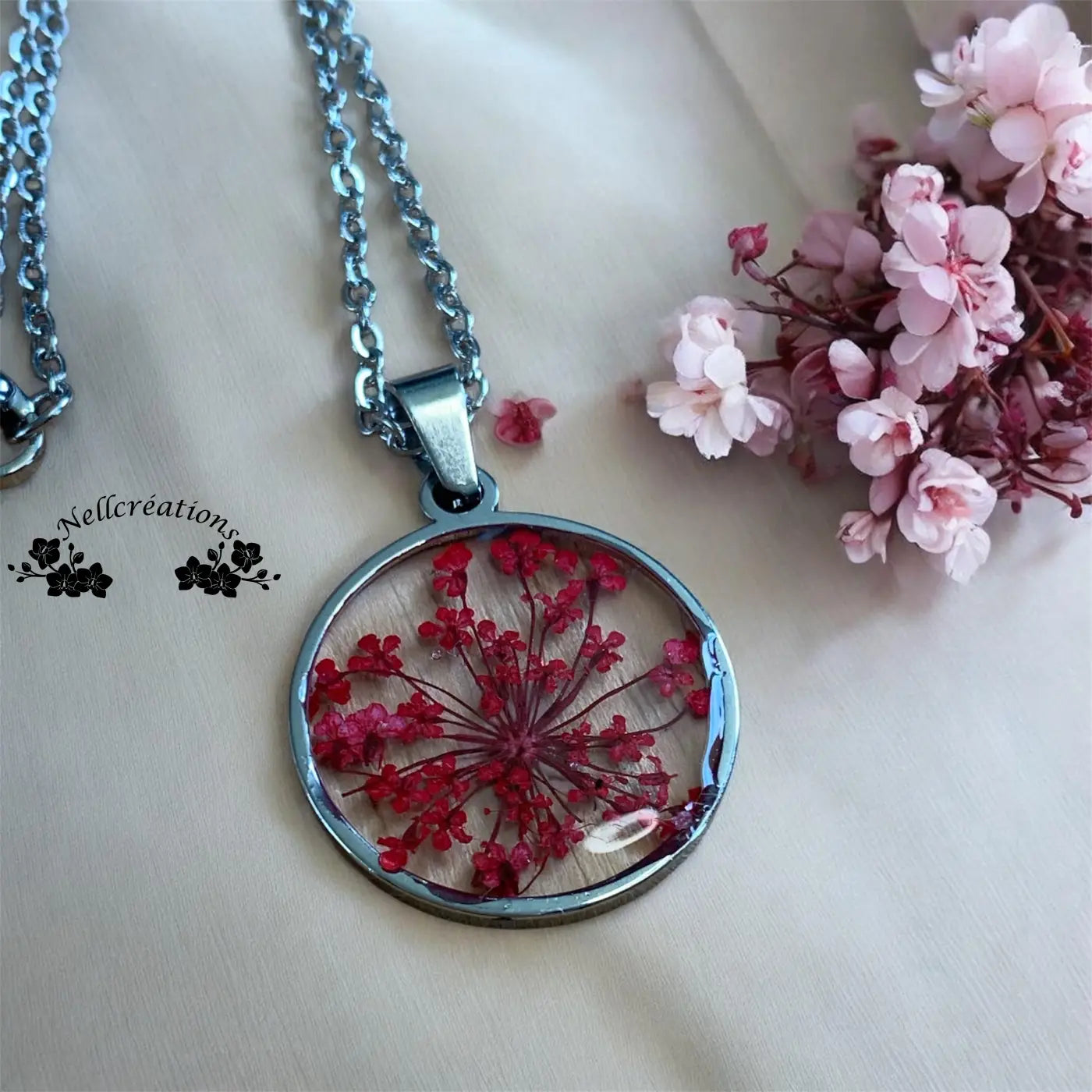 Pendentif circulaire en résine uv avec fleurs rouges séchées encadré dargent et chaîne assortie