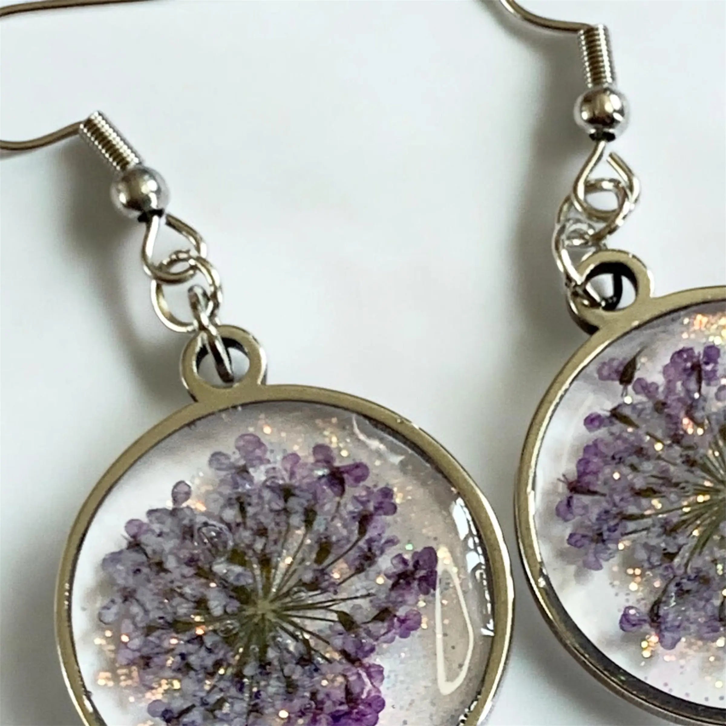 Boucles d’oreilles fleur de givre nellcréations avec fleurs séchées violettes délicates en résine claire et cadre métallique