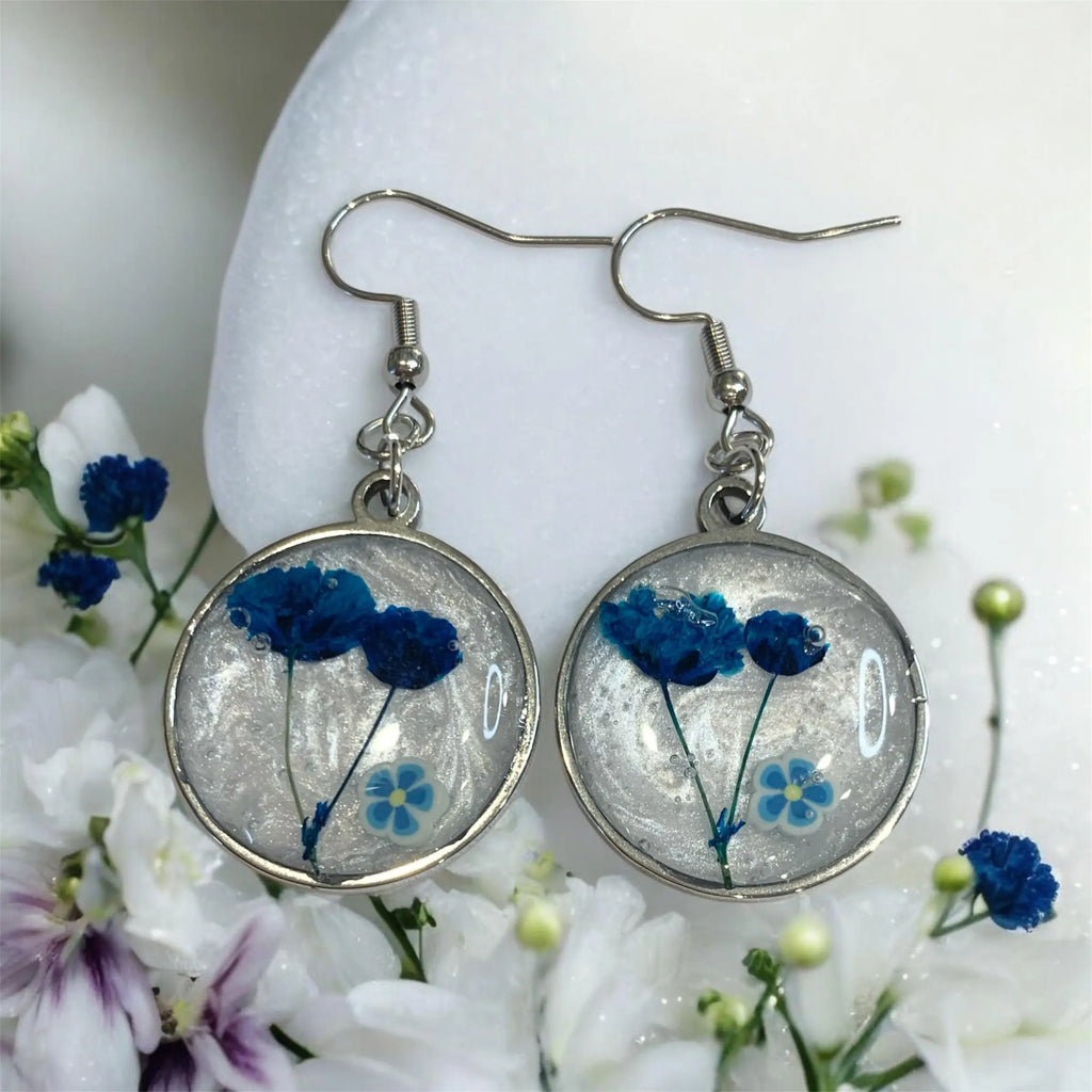 Boucles d’oreilles rondes argentées avec fleurs bleues préservées en résine claire jardin éternel bleu nellcréations