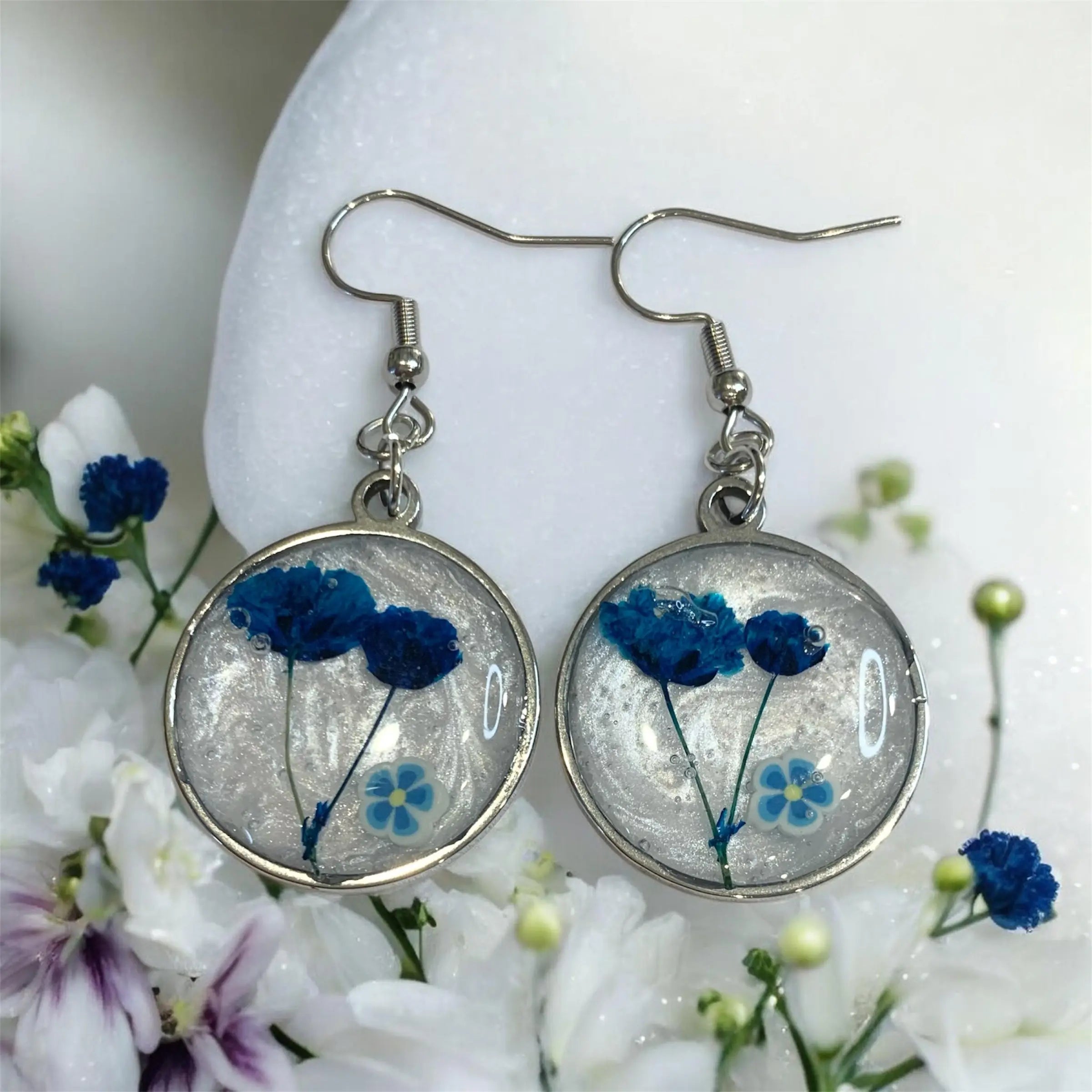 Boucles d’oreilles rondes argentées avec fleurs bleues préservées en résine claire jardin éternel bleu nellcréations
