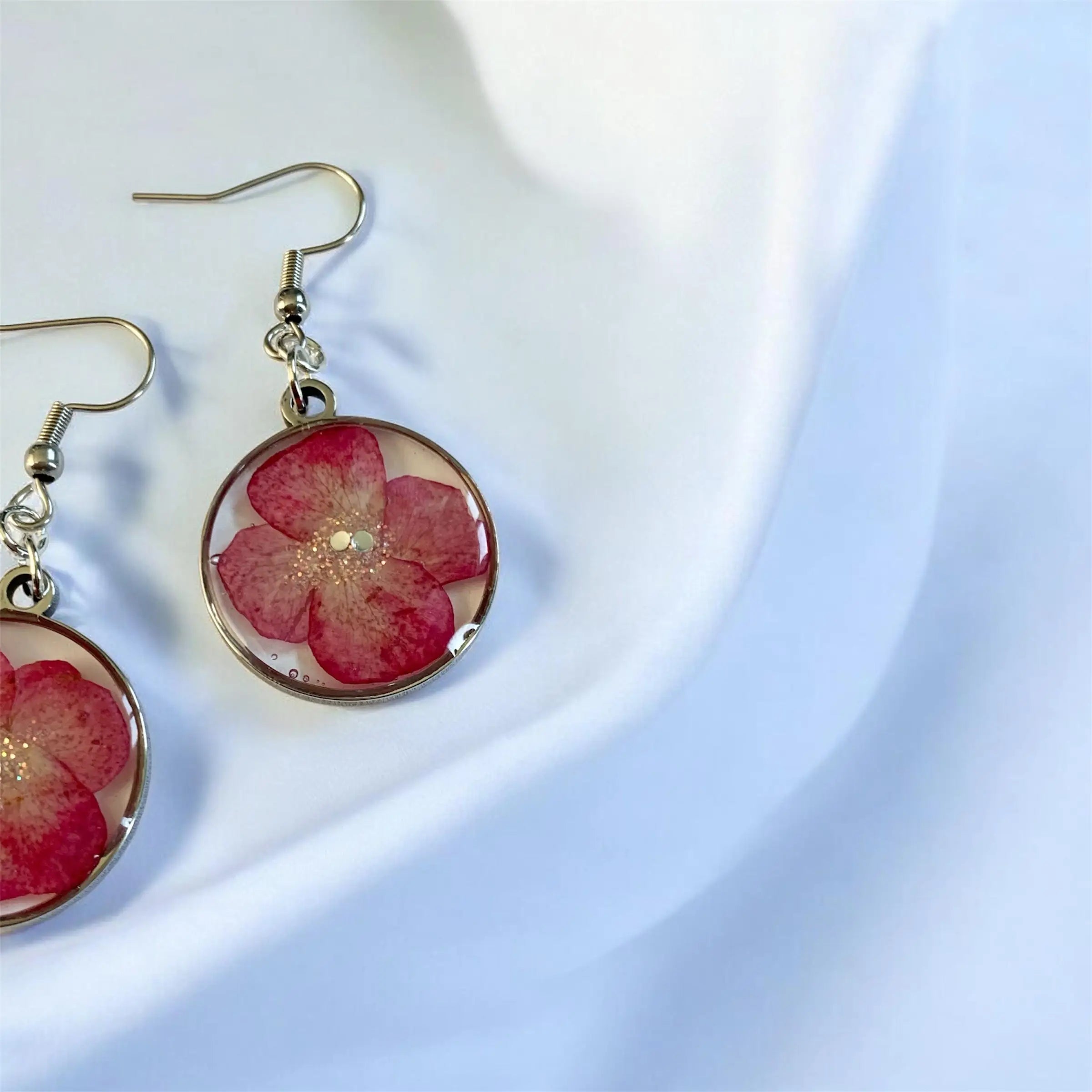 Boucles d’oreilles pétales d’été avec fleurs rouges circulaires en résine transparente et crochets métalliques dorés