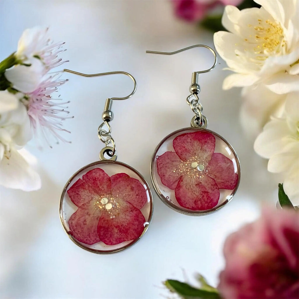 Boucles d’oreilles pétales d’été Nellcréations en résine claire avec fleurs roses préservées et cadre argenté circulaire