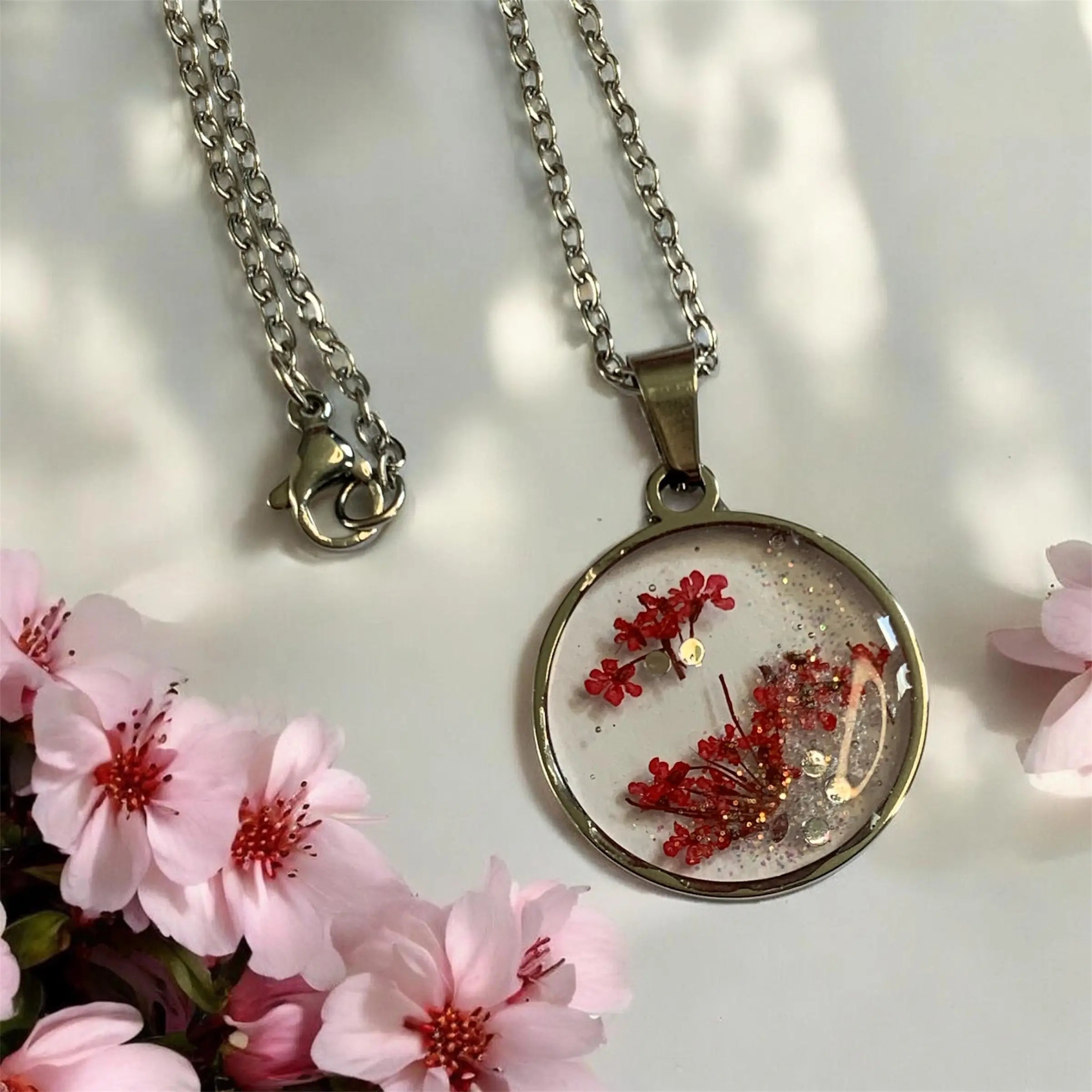 Collier rosa rouge éclat de nellcréations avec pendentif circulaire en argent et fleurs rouges séchées scintillantes