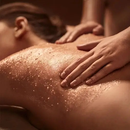 Gommage corps avec peau dorée brillante huilée massée par des mains pour exfoliation et soin corporel
