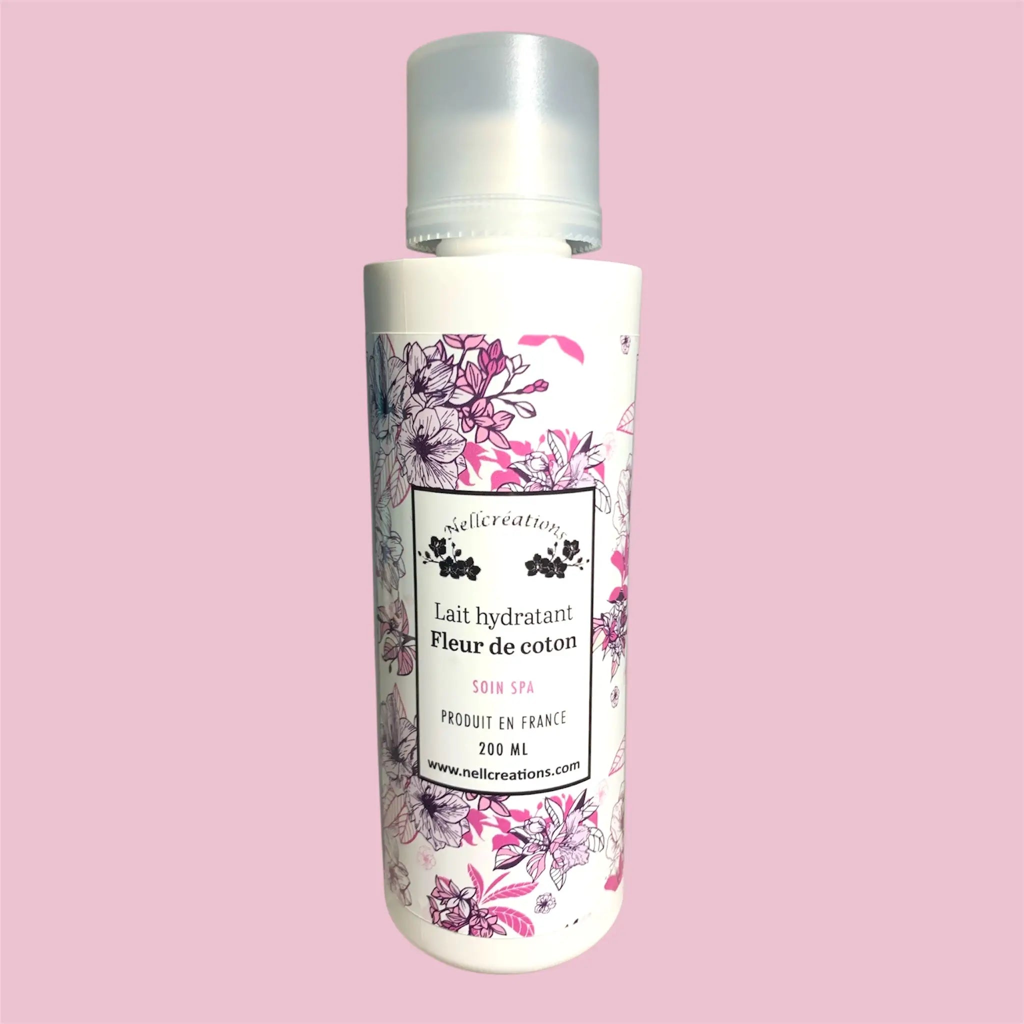 Bouteille blanche cylindrique avec capuchon transparent et étiquette fleurie rose noir lait hydratant fleur de coton nellcréations